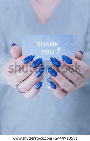 Female hands hold a picture with the inscription Thank you