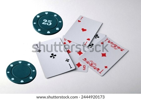 Aces playing cards with a usd 25 casino chip on a white background.a $25 pocket chip with a clean background on the hand