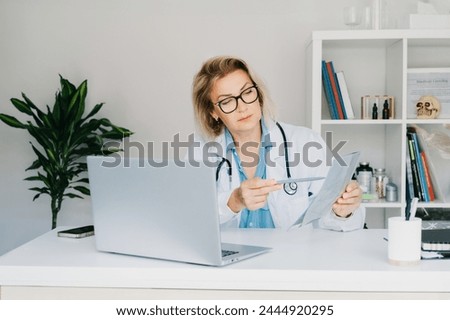 Female doctor makes online video call consult patient on laptop. Middle aged woman therapist videoconferencing for domestic health treatment. Telemedicine concept. Online remote medical appointment. Royalty-Free Stock Photo #2444920295