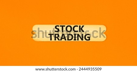 Stock trading symbol. Concept words Stock trading on beautiful wooden stick. Beautiful orange table orange background. Business stock trading concept. Copy space.