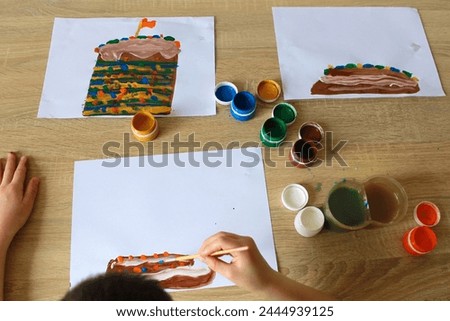 a child paints desserts with paints.