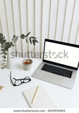 This image features a laptop computer, a notebook, a pen, and a pair of glasses neatly arranged on a clean desk. This is a great stock photo for business presentations, educational content, or back-to