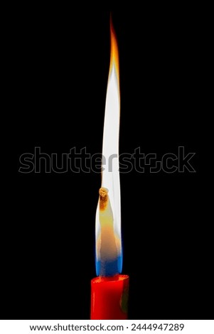 Minimalist picture of the flame of a red candle with a black background. HD.