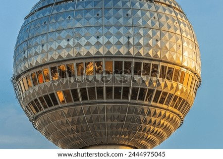 Detail of the sphere from the television tower in Berlin. Part of the tallest building in the capital of Germany with reflections on the window panes of the glass front in the evening in the sunshine.
