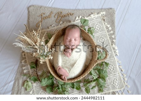 A Taiwanese newborn baby wrapped in a white wrap is taking a newborn photography while sleeping Royalty-Free Stock Photo #2444982111