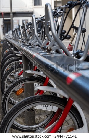 Racks for public bicycle services. red bikes are available for rent. City bike rental. Bicycles in the city. Ecological way of transport. Lots of bikes ready to rent

