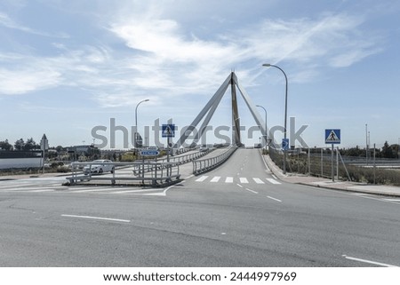 Image of the metal structure of a small bridge for road traffic and pedestrians, with indicative road traffic signage on a day with a bright sky