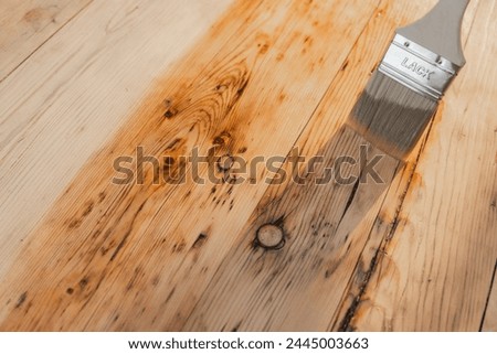 Impregnation of wood with oil and varnish.mans hand paints wooden boards with oil. Impregnation of a wood with protective oil. Protecting the wooden surface from damage. Royalty-Free Stock Photo #2445003663