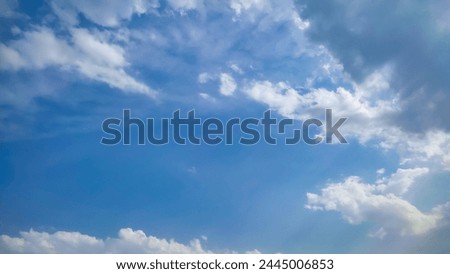 Many clouds spreading on the blue sky in daylight. Soft white and black fluffy clouds covered the blue sky. Nature concept. Rainy clouds in sunny day. Landscape photo