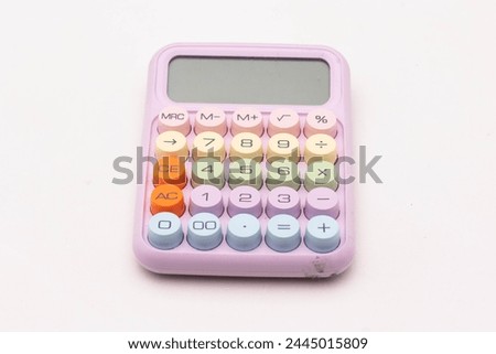 Simple pink-colored calculator with colorful buttons isolated on a white background