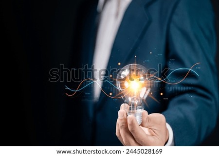 Businessman holding light bulb with Business graph analysis. Financial plan and strategy. Corporate strategy for finance, operations, sales, marketing.