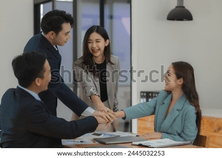 A group of employees join hands to encourage work before starting a big project assigned by an important customer of the company, Make a gesture of helping each other by joining hands together.
