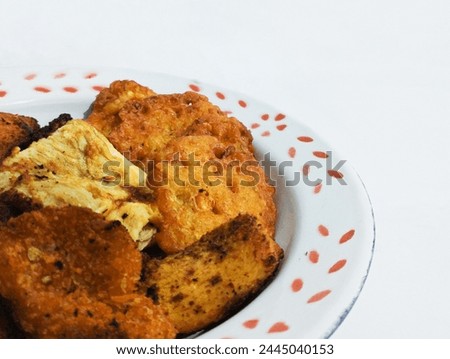 Picture of fried egg, chicken nuggets, Bakwan Jagung. Bakwan Jagung is Indonesian food made from corn mix with flower and some seasoning. Picture of fried food 