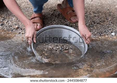 Woman panning for gold with a prospector's pan at Sovereign Hill tourist attraction. Ballarat, Victoria Australia Royalty-Free Stock Photo #2445084877