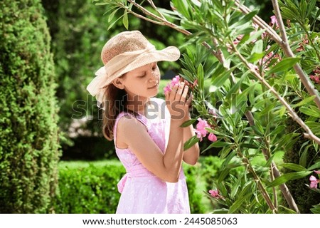Blossom Garden. Little Girl Enjoying with Flowers in Botanical Garden. Child in Blooming Fairy tail.