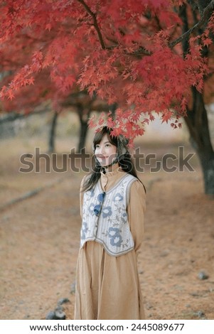 Asian woman in Japan's fall beauty, cheerful holiday portrait in yellow and red foliage. A journey capturing the essence of nature, fashion, and casual elegance.