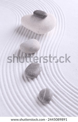 Zen garden stones on white sand with pattern Royalty-Free Stock Photo #2445089891