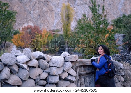 An Asian female tourist taking picture with the beautiful scenery at a quiet local village in Passu Valley, Gilgit-Baltistan, Pakistan.