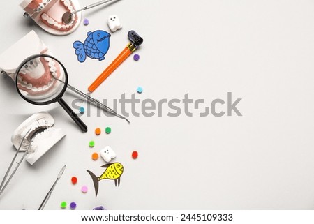 Composition with dentist's tools and decor for April Fools Day on light background