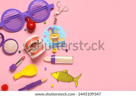 Composition with makeup accessories, jaw model and party decor on pink background. April Fools Day celebration