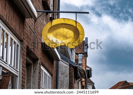 Barber shop sign, golden, in the streets of Tonder, Denmark