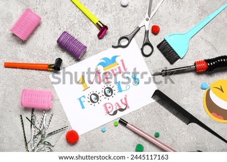 Card with text 1 APRIL FOOL'S, hairdresser's supplies and decor on grunge background