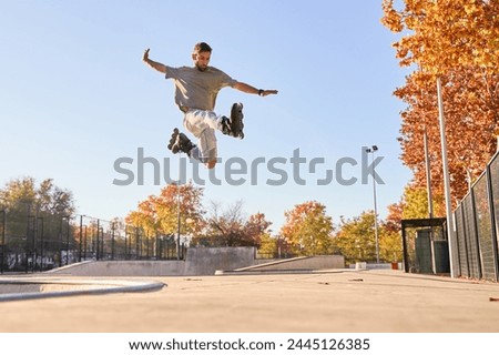 young male roller skater jumping and doing a trick with his inline skates. Royalty-Free Stock Photo #2445126385