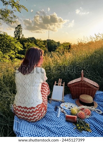 Painter's paradise: woman creates art during a picnic.