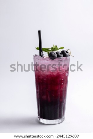 Cocktail with blueberries and mint on a white background.