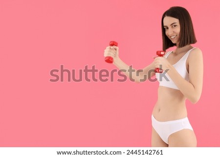 A slim girl in underwear, with a dumbbell, does sports.