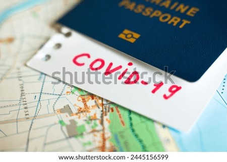 Passport and note with Covid-19 inscription. Coronavirus disease outbreak. Travelling in epidemic period. Passport border control and quarantine of infected tourists. Royalty-Free Stock Photo #2445156599