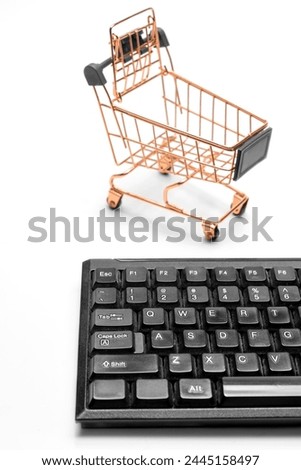 Model figure of shopping cart and computer keyboard isolated over white background. Black Friday and Cyber Monday concept. Business retail shop store marketing online. 
