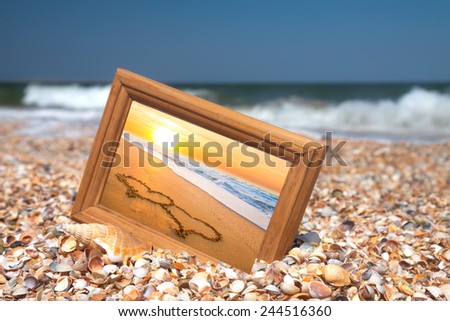 Photo frame on sand background, two hearts, love concept