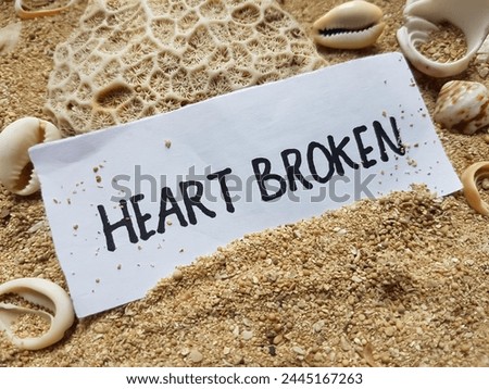 Heart broken writting on beach sand background.