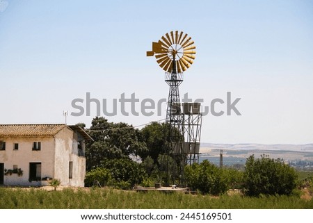 An American farm with a windmill is an iconic image that evokes rural life and connection to nature. These windmills are typical and referential in the agricultural world. Renewable energy concept