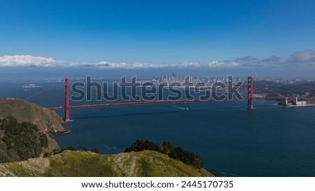 Golden Gate Bridge picture, taken on Hawk Hill. Sunny day with boats around the bridge. San Francisco cityscape in the far.