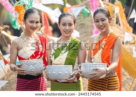 Songkran festival. Portrait Northern Thai people in Traditional clothes dressing handle handcrafted silver bowl in Songkran day summer Thailand cultural festival. Royalty-Free Stock Photo #2445174545