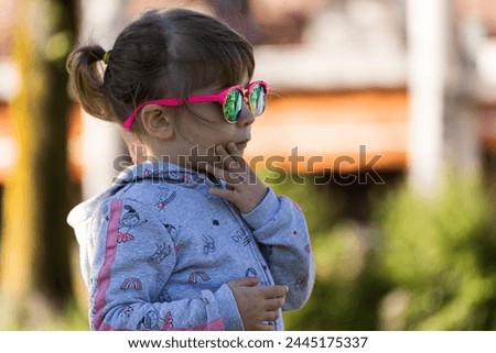 3 year old girl proudly wears sunglasses