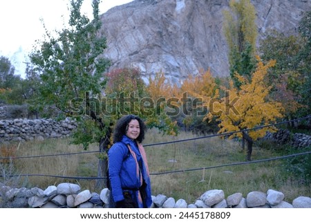 An Asian female tourist taking picture with the beautiful scenery at a quiet local village in Passu Valley, Gilgit-Baltistan, Pakistan.