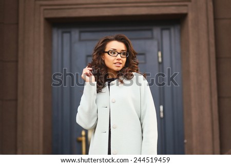 Portrait of young cheerful business woman in glasses looking away