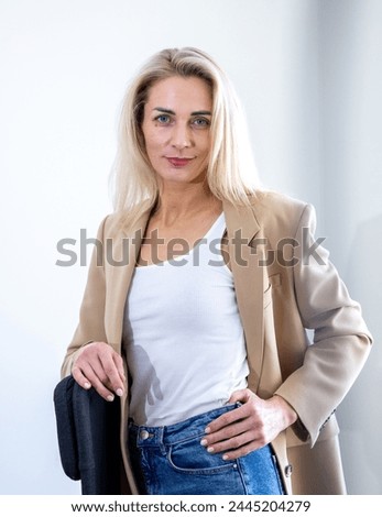 A cheerful business girl in a sand-colored jacket
