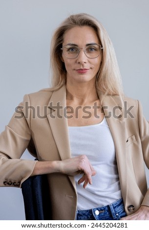A cheerful business girl in a sand-colored jacket