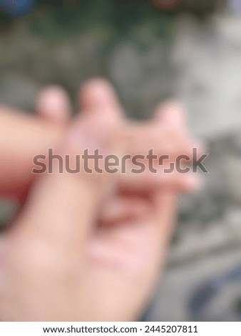 A photo of a mother holding her child's hand is out of focus