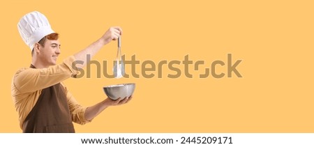 Male confectioner with bowl and whisk preparing tasty meringue on yellow background with space for text Royalty-Free Stock Photo #2445209171