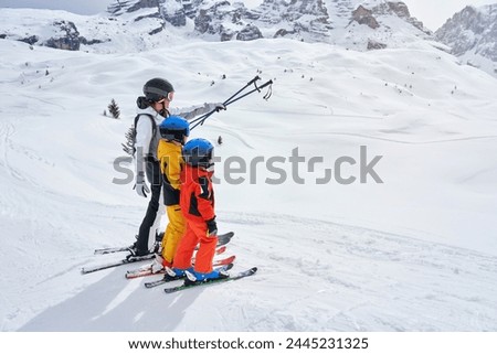 Picture of mother teach skiing her kids in Madonna di Campiglio