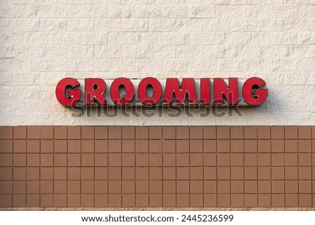 Red grooming sign on a wall of a famous pet store building 