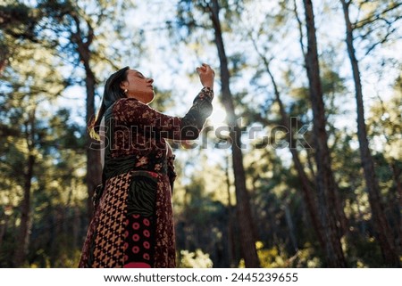 Concept of balance, harmony and health. girl alone with nature. a girl dances and sings in the forest among the trees. young and beautiful girl among natural landscapes.