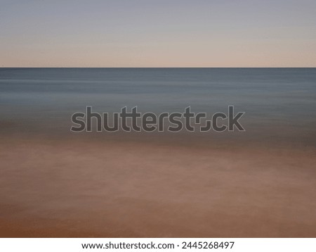 Horizon abstract seascape, warm transparent beach sand, and soft turquoise-colored sea water long exposure photography 