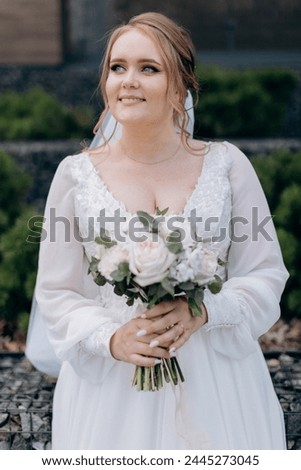 a blonde girl with blue eyes in a white dress looks at the camera, a loving look
