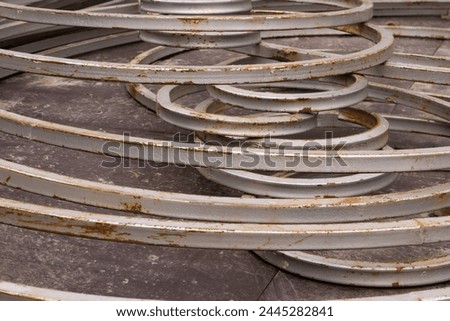 A closeup shot of the group of gray painted rusting metal fence segments forming multiple loops